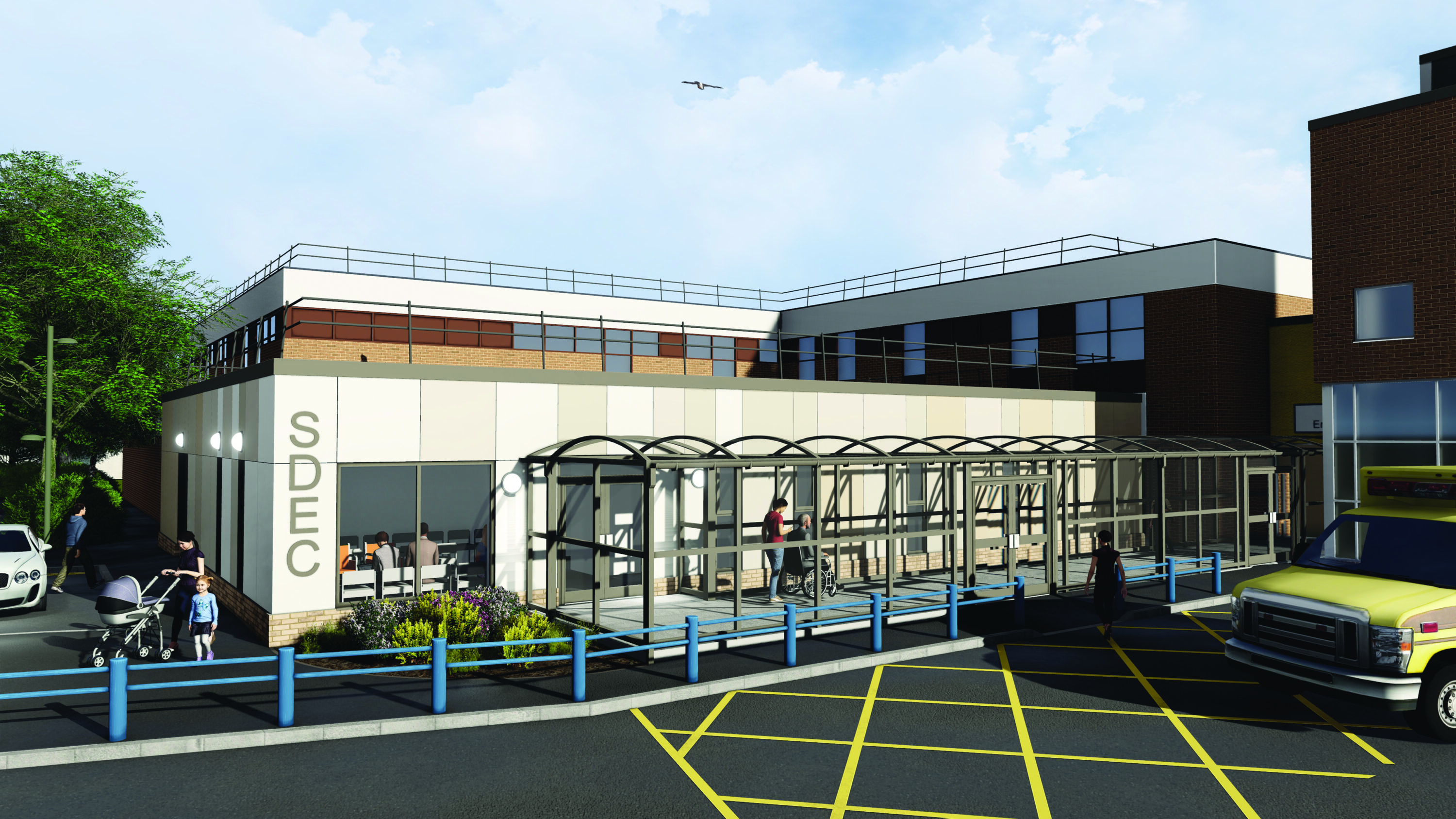 An architectural render of the SDEC building, showing the main front elevation with a long covered ramp leading to the main entrance.