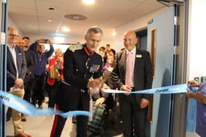 The Lord Lieutenant of Hampshire, cutting the ribbon at the opening ceremony for Hampshire Heart Centre. In the background is a large mixed group of people.