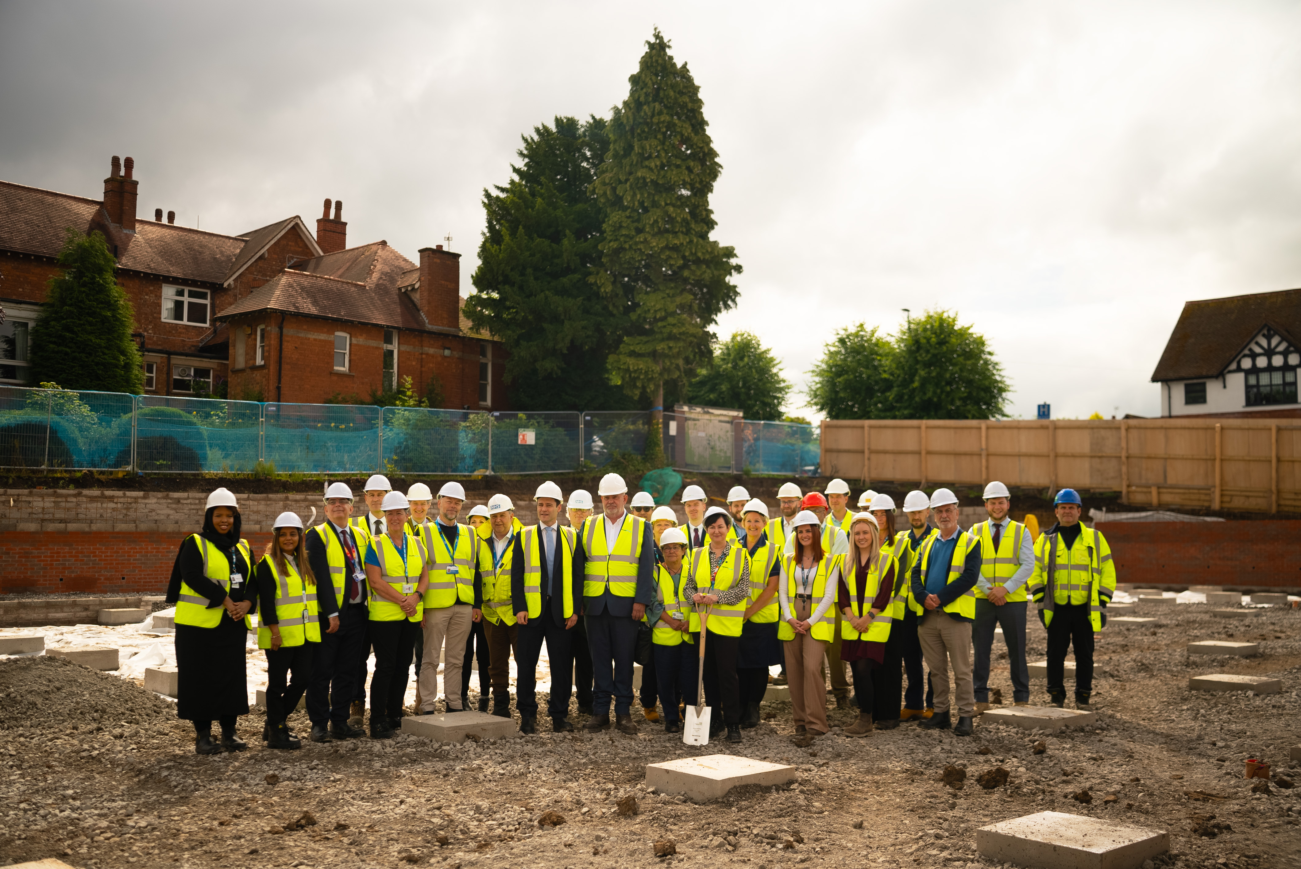 Group of people in high-vis vests and PPE, stood on the construction site for Hinckley community diagnostic centre